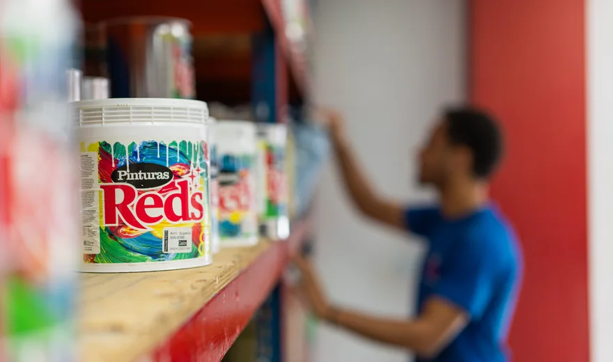 Estante de ferretería con cubetas de Pinturas Reds